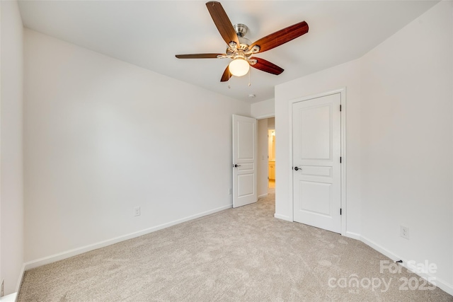 unfurnished bedroom with light carpet, ceiling fan, and baseboards