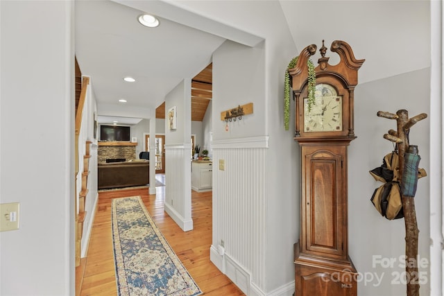 hallway with a wainscoted wall, light wood-style flooring, and recessed lighting