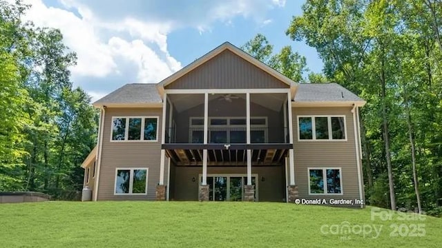 rear view of property featuring a yard and a sunroom