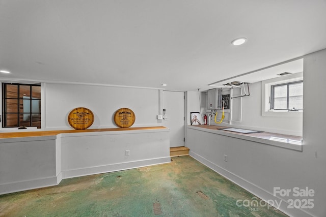 interior space featuring recessed lighting, concrete floors, and baseboards