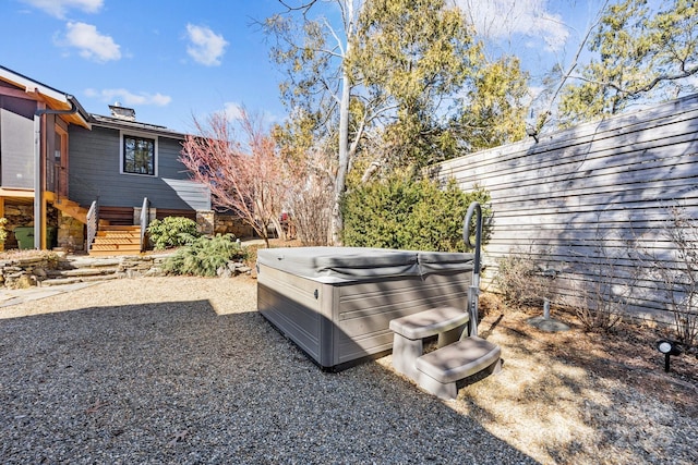 view of yard featuring fence and a hot tub