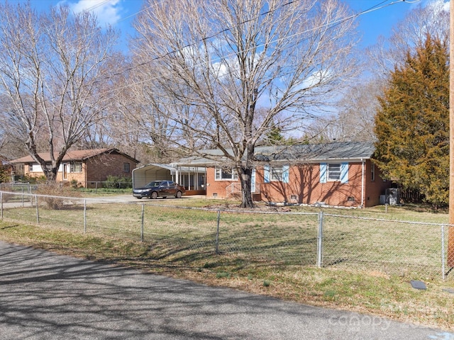 ranch-style house with a carport, a front yard, crawl space, and a fenced front yard