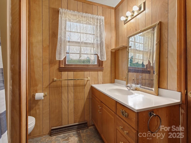 half bath featuring visible vents, vanity, toilet, and wooden walls