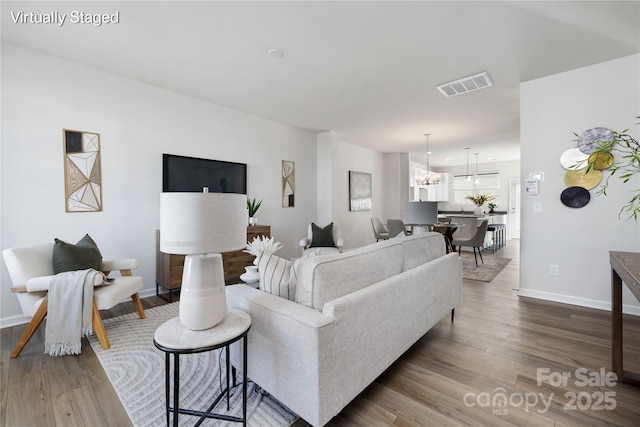 living room with hardwood / wood-style flooring and an inviting chandelier