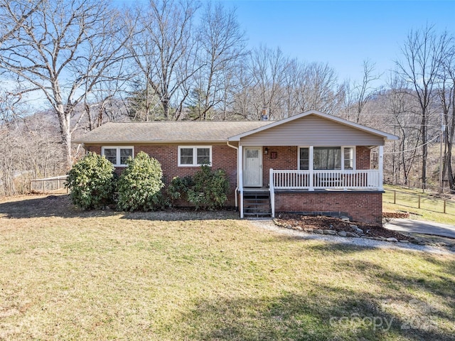 ranch-style house featuring covered porch and a front yard