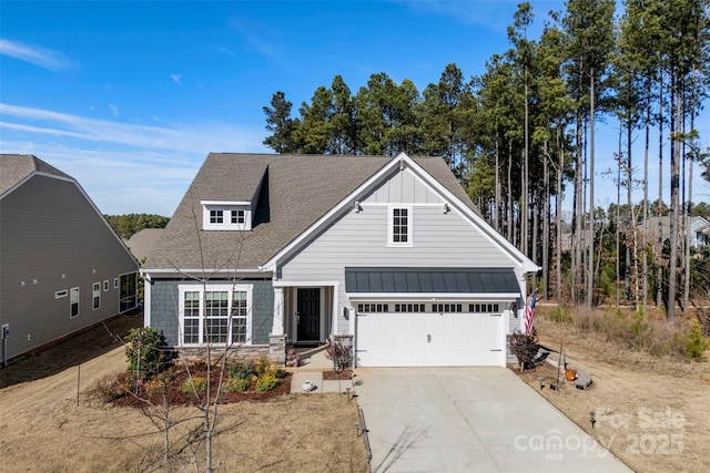 view of front of house featuring roof with shingles, concrete driveway, board and batten siding, a standing seam roof, and a garage