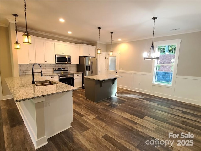 kitchen featuring sink, stainless steel appliances, kitchen peninsula, white cabinets, and hanging light fixtures