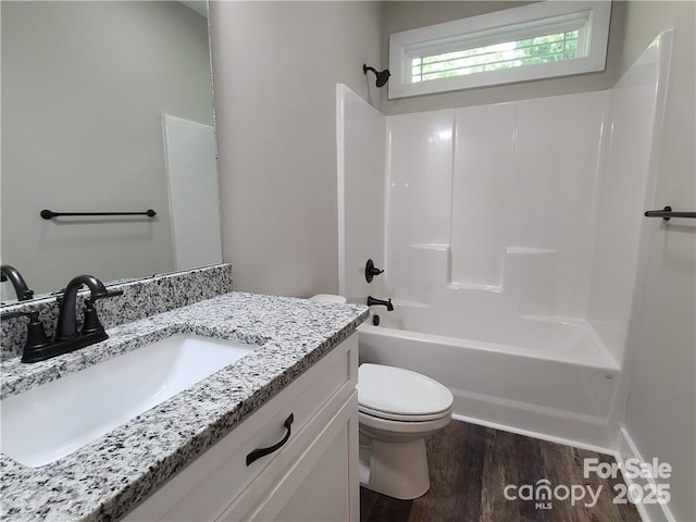 full bathroom featuring washtub / shower combination, toilet, vanity, and hardwood / wood-style floors