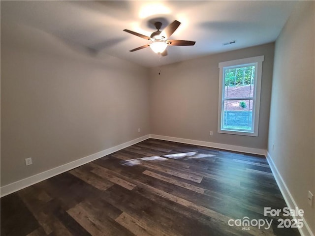 spare room featuring dark hardwood / wood-style flooring and ceiling fan