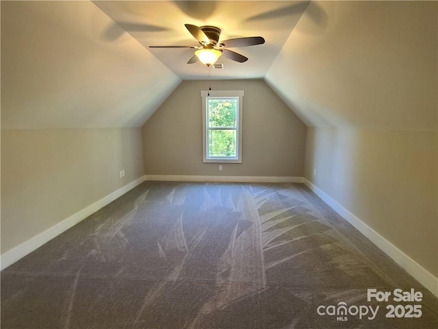 bonus room featuring vaulted ceiling, dark carpet, and ceiling fan