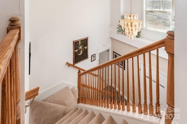 stairs with a notable chandelier