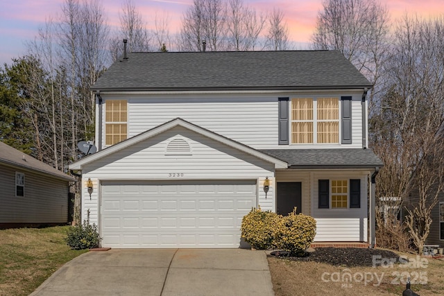 traditional home featuring driveway and a shingled roof