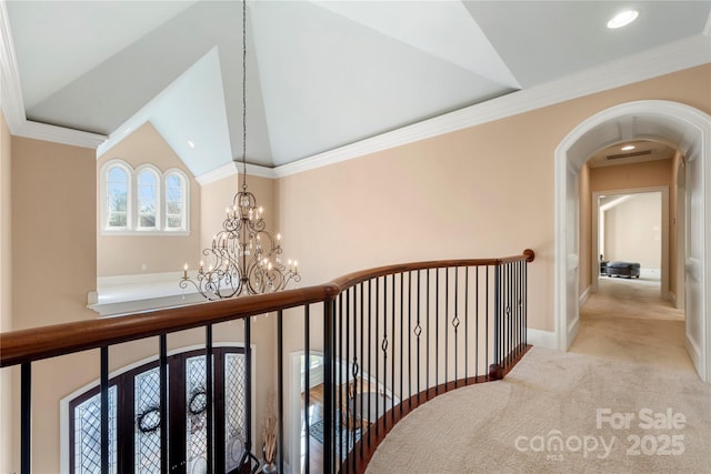 corridor featuring arched walkways, light colored carpet, baseboards, an inviting chandelier, and crown molding