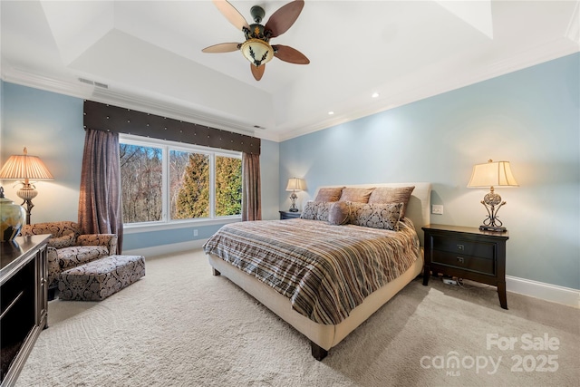 carpeted bedroom featuring a ceiling fan, visible vents, baseboards, ornamental molding, and a raised ceiling