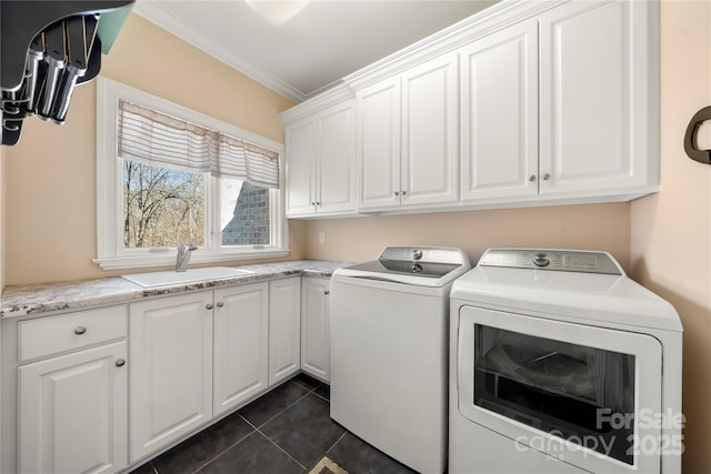 laundry area with washing machine and dryer, dark tile patterned floors, a sink, cabinet space, and crown molding