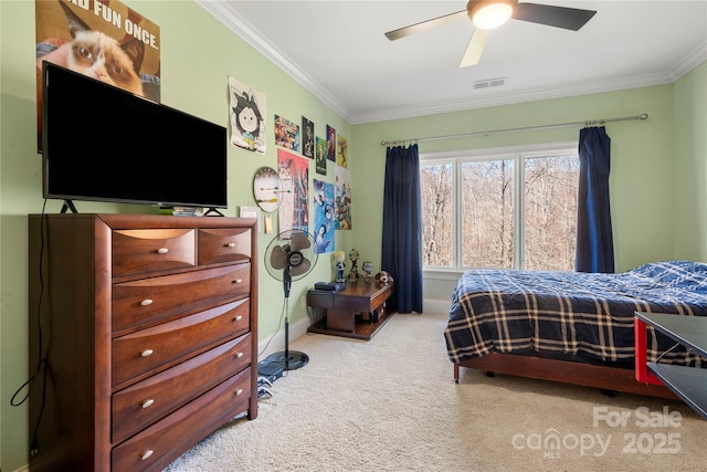 carpeted bedroom featuring baseboards, a ceiling fan, visible vents, and crown molding