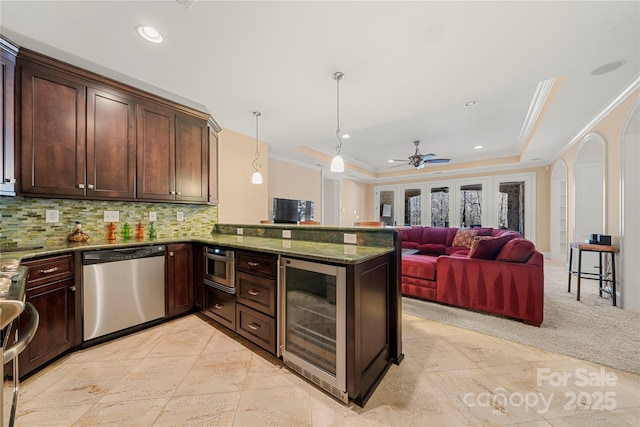 kitchen featuring wine cooler, decorative light fixtures, open floor plan, dishwasher, and a peninsula