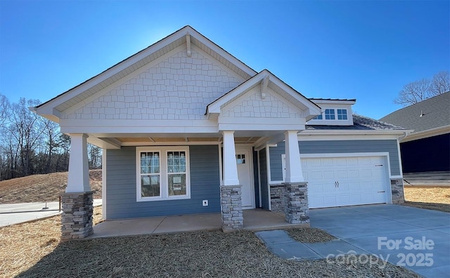 craftsman inspired home featuring covered porch and a garage