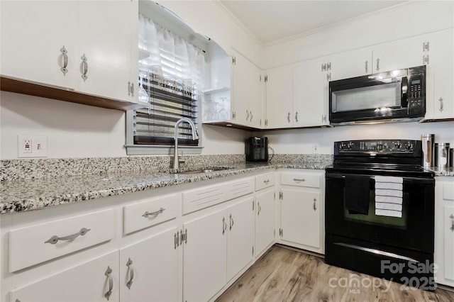 kitchen with light wood-style flooring, ornamental molding, white cabinetry, a sink, and black appliances