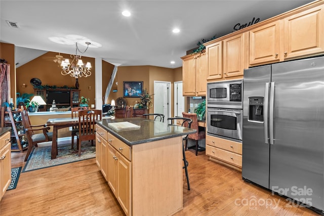 kitchen with light brown cabinets, stainless steel appliances, visible vents, light wood finished floors, and an inviting chandelier