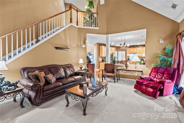 living area with light carpet, visible vents, stairway, high vaulted ceiling, and a notable chandelier