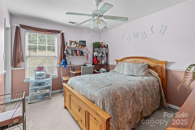 bedroom with baseboards, ceiling fan, visible vents, and light colored carpet