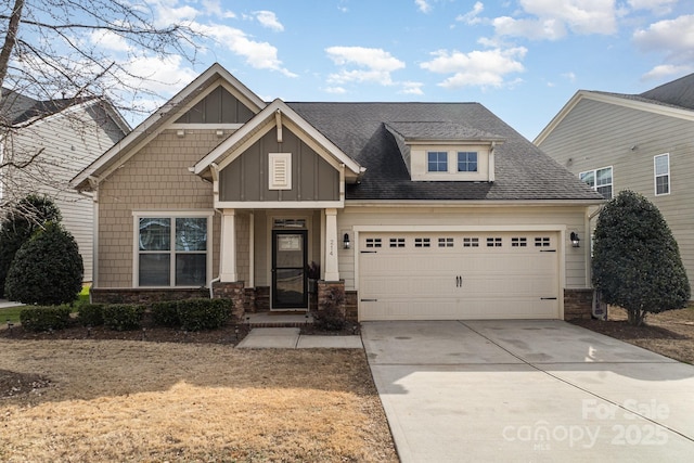 craftsman house with concrete driveway, stone siding, roof with shingles, an attached garage, and board and batten siding