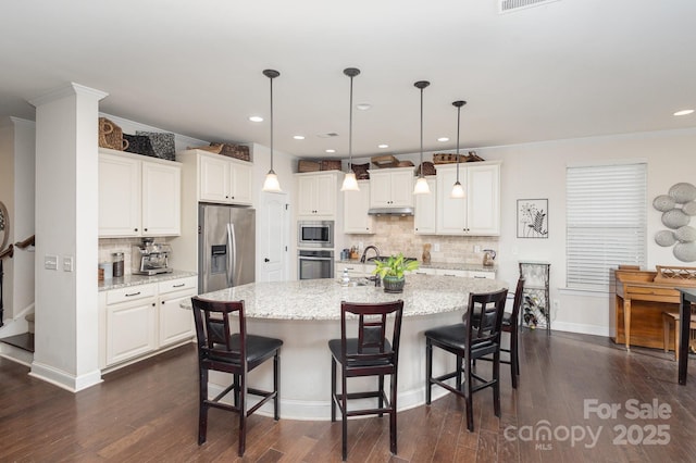 kitchen with appliances with stainless steel finishes, dark wood-style flooring, and white cabinets