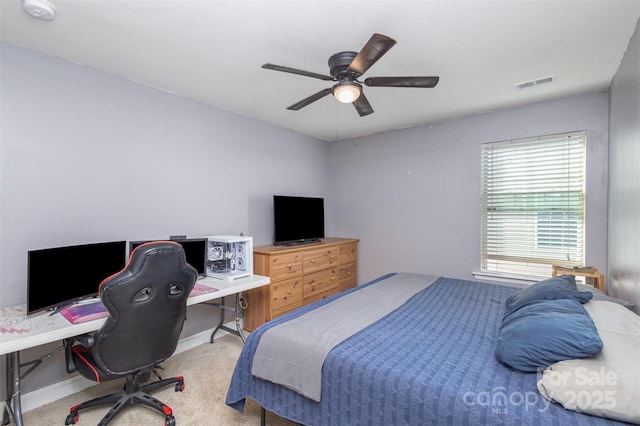 carpeted bedroom featuring a ceiling fan, visible vents, and baseboards