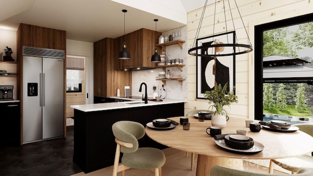 kitchen featuring a healthy amount of sunlight, pendant lighting, backsplash, and built in refrigerator