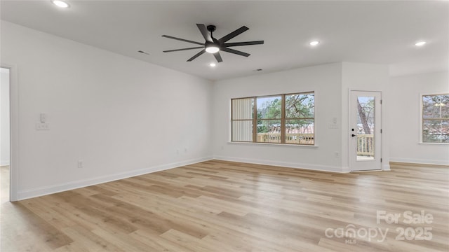 unfurnished living room with baseboards, recessed lighting, and light wood-style floors