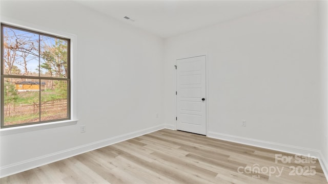 unfurnished room featuring baseboards and light wood-style flooring