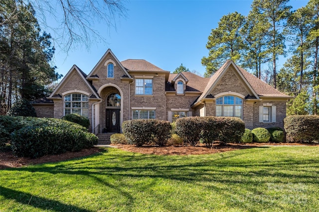 view of front of house with a front lawn and brick siding