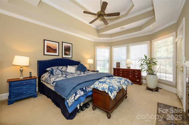 bedroom featuring carpet floors, a tray ceiling, multiple windows, and ornamental molding