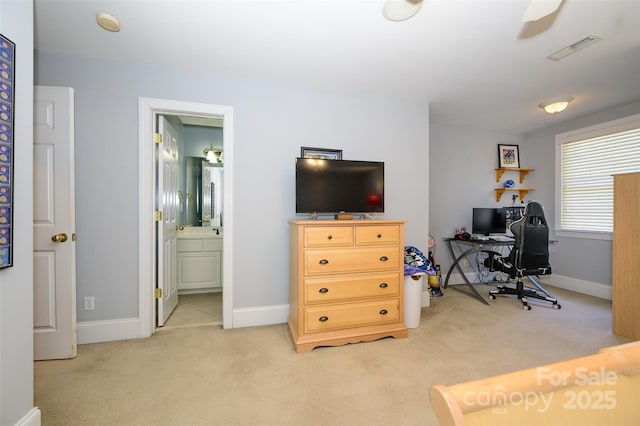 office space featuring baseboards, visible vents, and light colored carpet