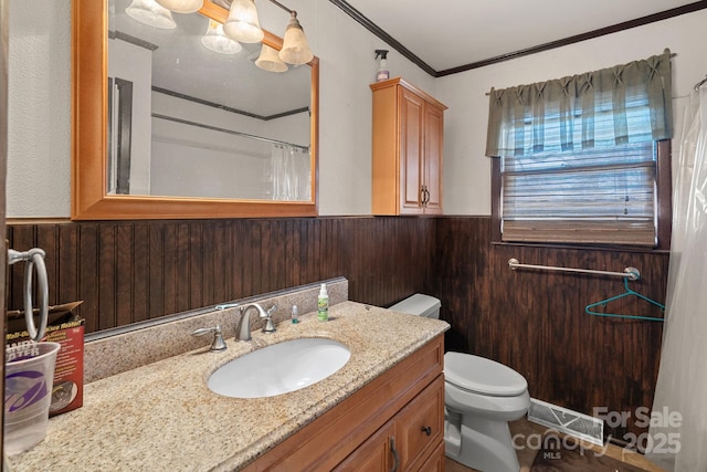 bathroom featuring a wainscoted wall, visible vents, toilet, wooden walls, and vanity