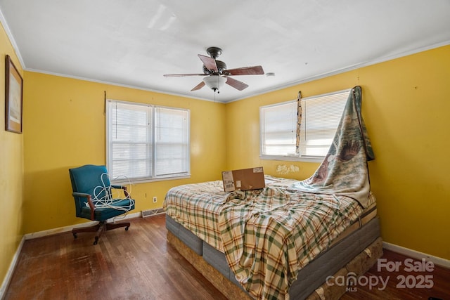 bedroom featuring wood finished floors, visible vents, a ceiling fan, baseboards, and ornamental molding