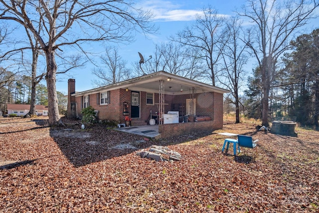 rear view of property with brick siding and a chimney