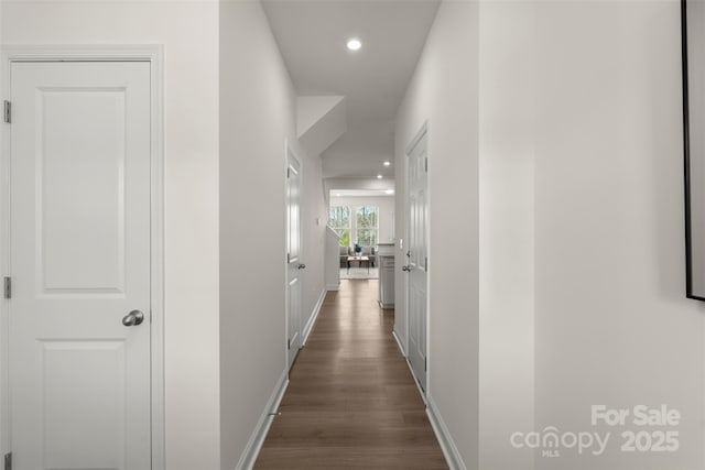 hall with baseboards, dark wood-style flooring, and recessed lighting