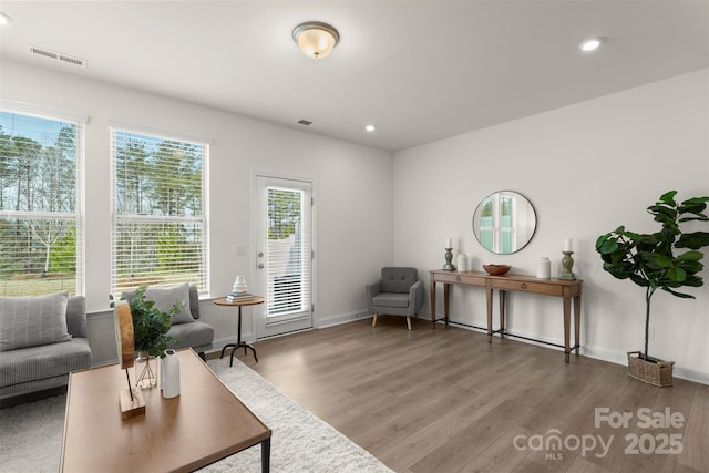 living area with visible vents, wood finished floors, and recessed lighting