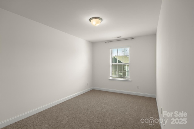 carpeted spare room featuring visible vents and baseboards