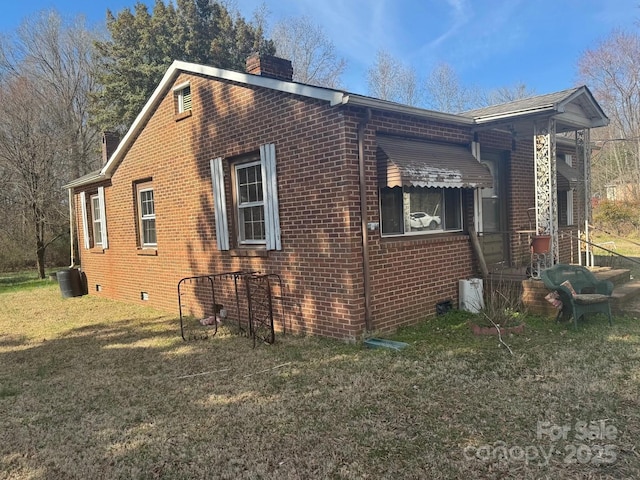 view of home's exterior with crawl space, a yard, a chimney, and brick siding