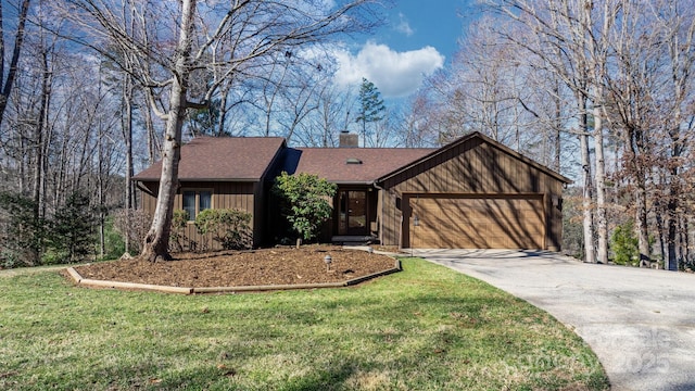 view of front of house featuring a front yard, concrete driveway, a chimney, and an attached garage