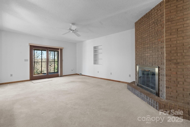 unfurnished living room with a textured ceiling, ceiling fan, carpet floors, baseboards, and a brick fireplace