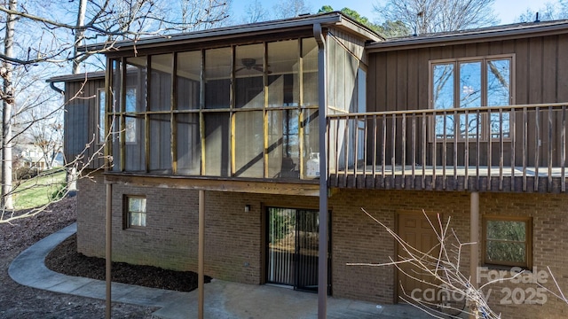 rear view of house featuring a patio, brick siding, and a sunroom