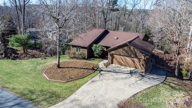 view of front facade featuring a garage, driveway, a front lawn, and roof with shingles