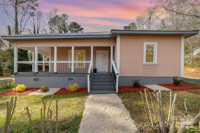 view of front of home featuring crawl space, covered porch, metal roof, and stucco siding