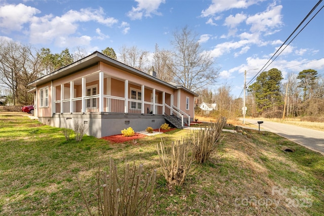 view of side of property featuring crawl space, a porch, and a lawn