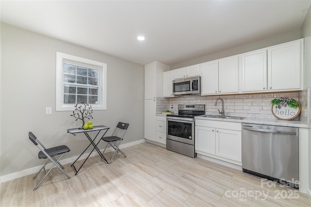 kitchen with white cabinets, tasteful backsplash, stainless steel appliances, and a sink