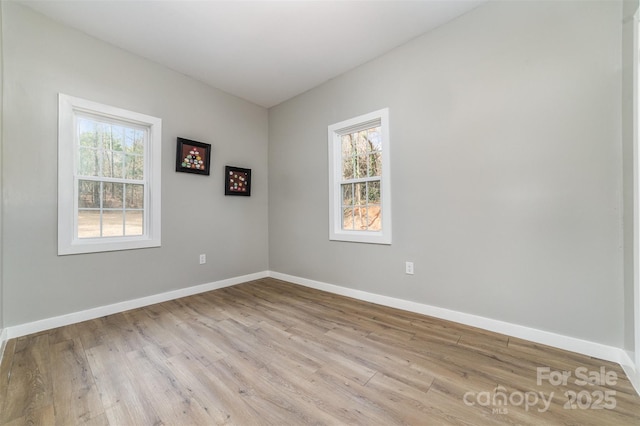 unfurnished room featuring baseboards and light wood-style floors